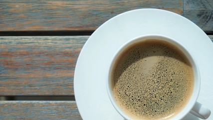top view on cup of coffee with foam on wooden table