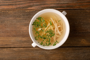 Stock with noodles and white meat on wooden