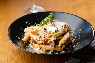Penne pasta with mushrooms sauce close-up