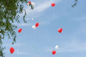 heart shaped balloon with cards in the sky