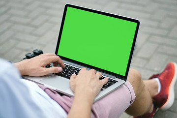 Young man using laptop in the park