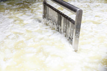 Hot milk mixing in the stainless tank during the fermentation process at the cheese manufacturing.