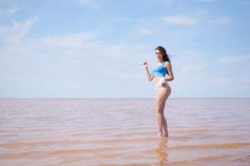 Fototapeta premium Sexy young woman posing near the pink lake