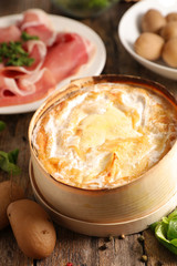 baked mont d'or, french dish, with ham and potatoes