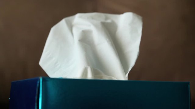 Box hygiene napkins on the brown sofa.