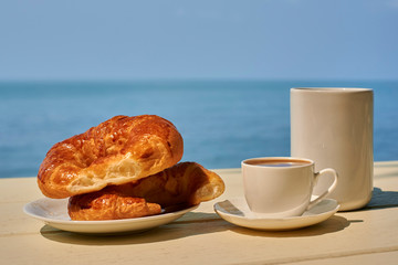 croissant with coffee on the sea