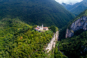 Fototapeta na wymiar Sanctuary on the edge of the cliff in the Alps - aerial view