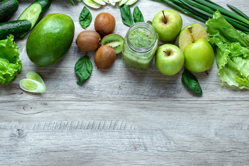 Fresh green food on a light table. Avocados cucumbers cabbage apples beans kiwi onions broccoli. The concept of healthy food, detox vegetarianism. Copy space flat lay.