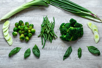 Fresh green food on a light table. Avocados cucumbers cabbage apples beans kiwi onions broccoli. The concept of healthy food, detox vegetarianism. Copy space flat lay.