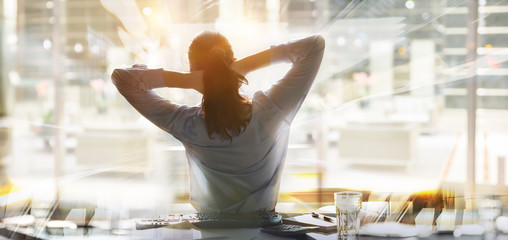 Young woman in office by the desk. Happy business concept, job, professional position, success in career, achievement and stability. 