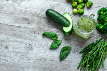 Fresh green food on a light table. Avocados cucumbers cabbage apples beans kiwi onions broccoli. The concept of healthy food, detox vegetarianism. Copy space flat lay.