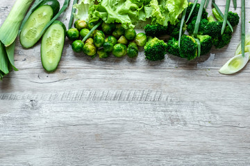 Fresh green food on a light table. Avocados cucumbers cabbage apples beans kiwi onions broccoli. The concept of healthy food, detox vegetarianism. Copy space flat lay.
