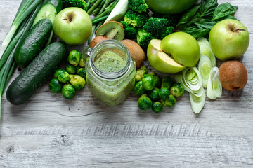 Fresh green food on a light table. Avocados cucumbers cabbage apples beans kiwi onions broccoli. The concept of healthy food, detox vegetarianism. Copy space flat lay.