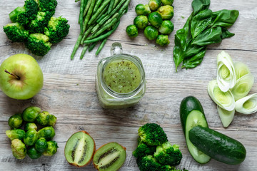 Fresh green food on a light table. Avocados cucumbers cabbage apples beans kiwi onions broccoli. The concept of healthy food, detox vegetarianism. Copy space flat lay.
