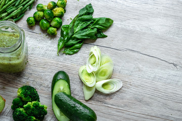 Fresh green food on a light table. Avocados cucumbers cabbage apples beans kiwi onions broccoli. The concept of healthy food, detox vegetarianism. Copy space flat lay.