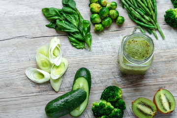 Fresh green food on a light table. Avocados cucumbers cabbage apples beans kiwi onions broccoli. The concept of healthy food, detox vegetarianism. Copy space flat lay.