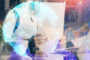 Double exposure of hands making notes with forex chart huds. Stock market concept.