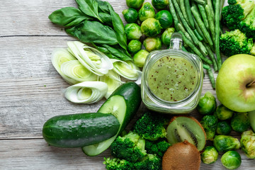 Fresh green food on a light table. Avocados cucumbers cabbage apples beans kiwi onions broccoli. The concept of healthy food, detox vegetarianism. Copy space flat lay.