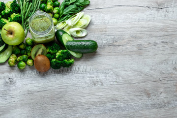 Fresh green food on a light table. Avocados cucumbers cabbage apples beans kiwi onions broccoli. The concept of healthy food, detox vegetarianism. Copy space flat lay.
