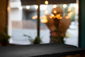 Empty wood table top on blur light gold bokeh of cafe restaurant in dark background