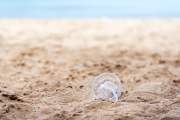 Fototapeta na wymiar Closeup image of a plastic glass garbage on the beach