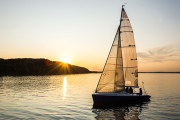 Sailing boat sailing into the harbor during beautiful sunset