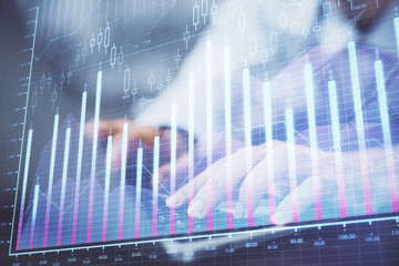Forex graph with businessman typing on computer in office on background. Concept of analysis. Double exposure.