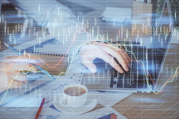 Forex graph with businessman working on computer in office on background. Concept of hardworking. Multi exposure.