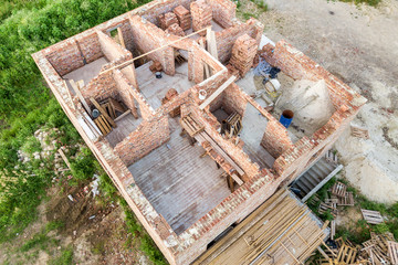 Aerial view of building site for future house, brick basement floor and stacks of brick for construction.