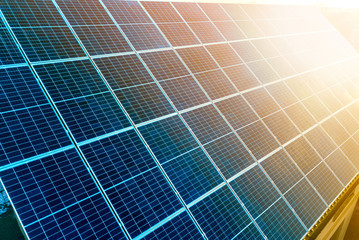 Close-up surface of lit by sun blue shiny solar photo voltaic panels. System producing renewable...