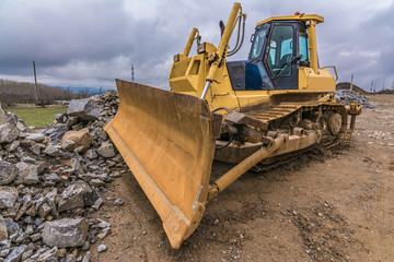 Excavator moving stone at a construction site