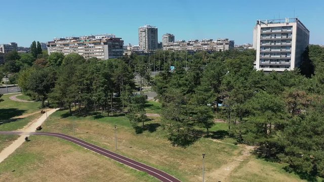 Fly above drone shot of Usce park with running path near Hotel Yugoslavia in Belgrade, Serbia
