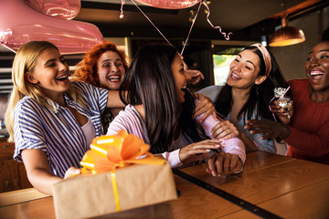 Group of girls surprise their girlfriend with a birthday party at a coffee shop.
