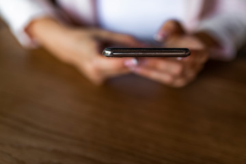 Using mobile phone. Woman using smart phone in cafe. Surfing the net. Business women hand are using cell phones in office. Close up of hands using mobile application on smartphone