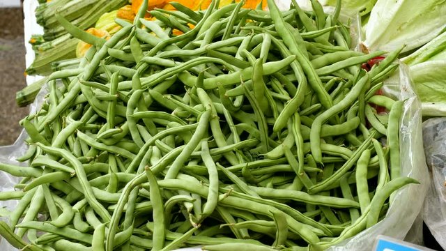Fresh vegetables. Close-up shot of pods of green beans at food market. Greece. 4K