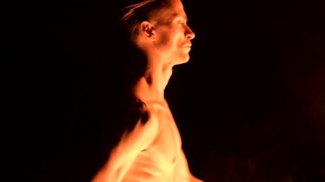 Fire show. Man juggles with two burning torches. Night show. Mastery of the fakir. Close-up