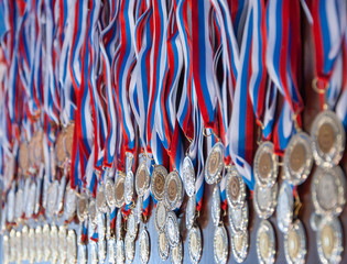A lot of gold medals with ribbons
