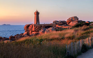 Fototapeta na wymiar Sunset view of the Ploumanac'h Lighthouse (the Mean Ruz Lighthouse) in Perros-Guirec on the Pink Granite Coast or Côte de Granit Rose. Brittany, France.