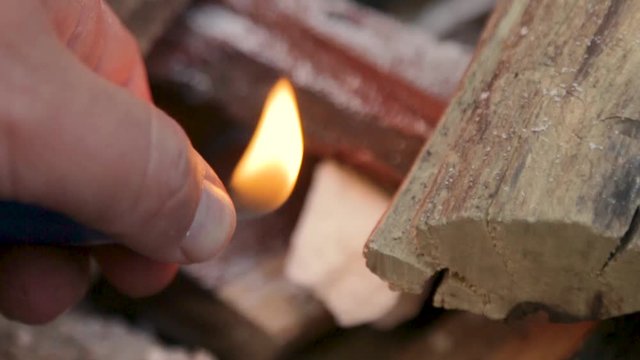 Man igniting a fire with a lighter