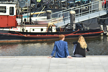 a man and a woman sitting on the pier Holland, Amsterdam