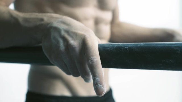 Athletic man working out on dip bars at the gym