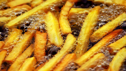 Crispy french fries in boiling oil