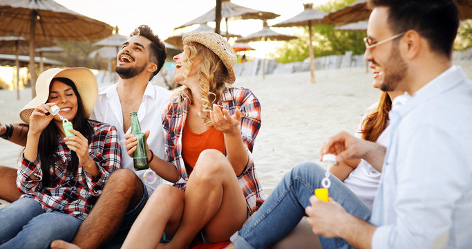 Beach party with friends. Cheerful young people spending nice time together on the beach