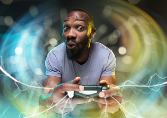 Full immersion in gameplay. Young man holding a video game controller isolated on colorful...