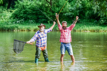 Bearded men catching fish. Master baiter. Mature man with friend fishing. Summer vacation. Happy cheerful people. Fisherman with fishing rod. Activity and hobby. Fishing freshwater lake pond river