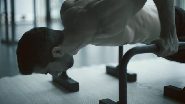 Man doing push-ups on dip bars at the gym