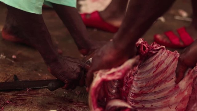 Goat carcass being boned out with knife in traditional African village. Filmed in the city Ibidan, in Oyo, Nigeria.
