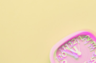 Pink alarm clock object on yellow background. Glitch style effect. Vibrant duotone yellow, violet colors. Top view.
