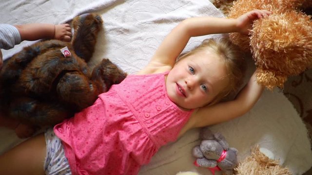 a little girl throws a plush toy