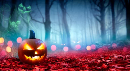 Foto auf Acrylglas Pumpkin On Red Leaves In Spooky Forest With Ghost Smoke - Halloween © Romolo Tavani